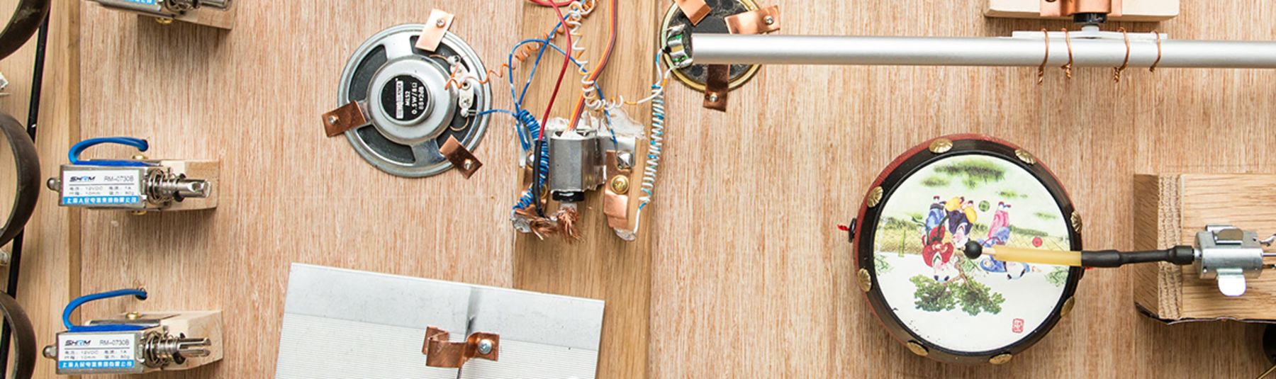 electronics, speaker heads and wires on a wooden board