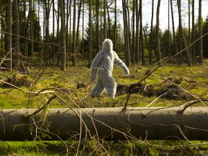 A person walking through a forrest in a white fluffy suit