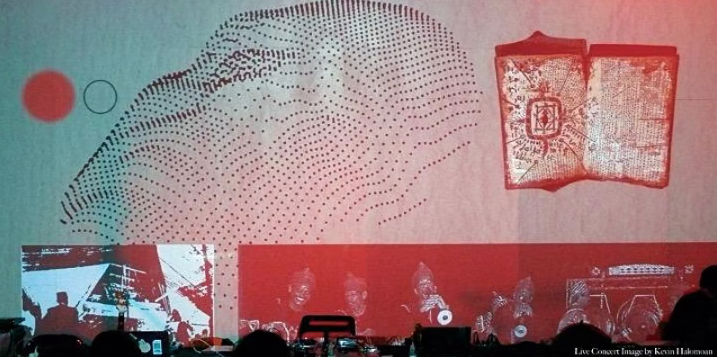 Projections on a wall showing people playing instruments and a face made of dots next to an open book
