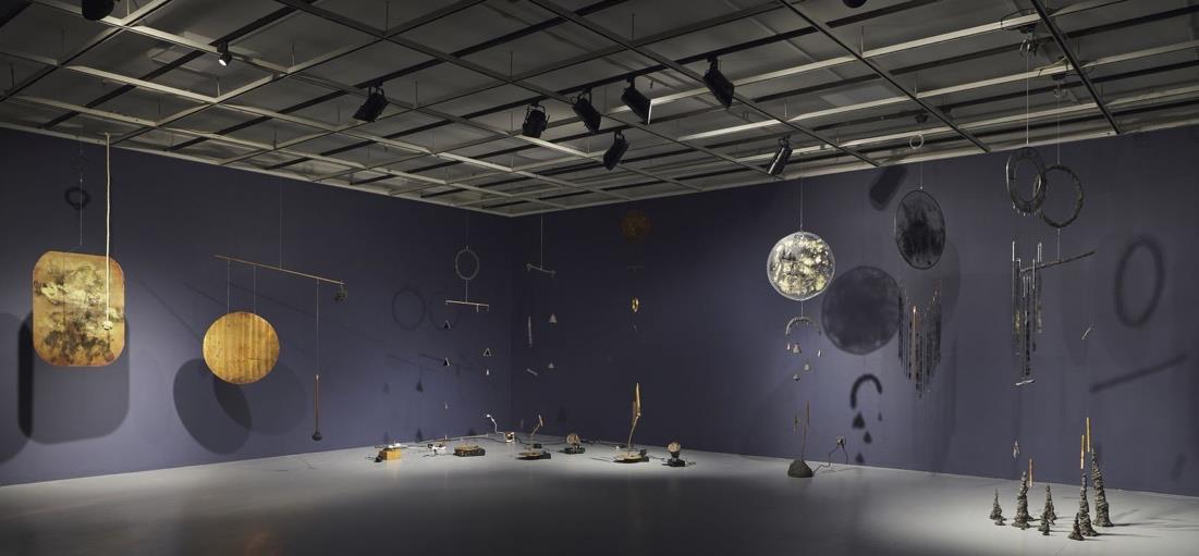 An installation of metal objects and mobiles handing in a gallery