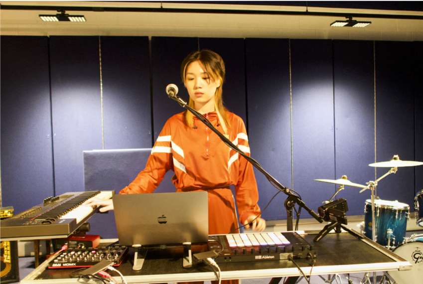 Profile image of Chen at a desk with computer, sound kit and microphone